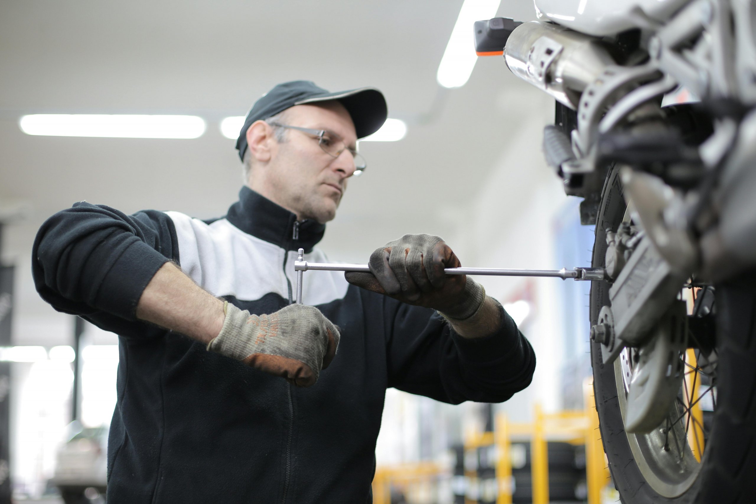 Mechanic in a garage working on a car, representing hardworking 9-5 business owners looking to start an online business for freedom and family time.